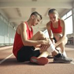 personne qui fait un bandage à un sportif