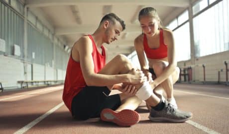 personne qui fait un bandage à un sportif